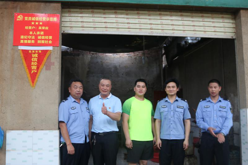 3为市场经营联合党支部为民族市场鸡鸭行吴荣应(左二)诚信经营户挂流动红旗